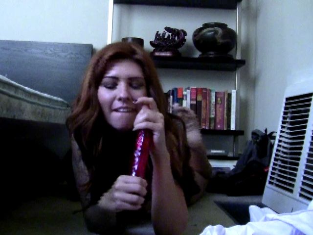 Redheaded amateur exgirlfriend Daphney sucking a long red dildo on the floor
